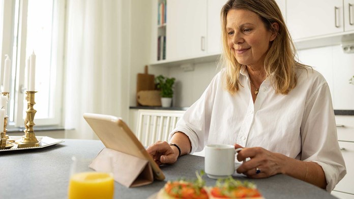 Kvinna vid frukostbord med Ipad