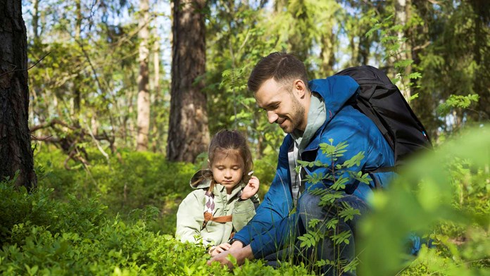 Pappa med barn i skogen