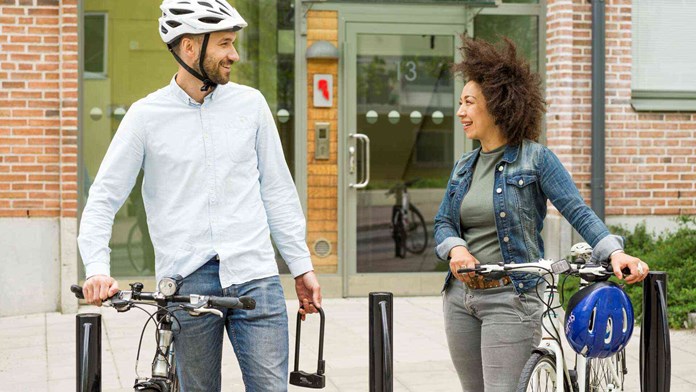 Man och kvinna med cyklar vid port