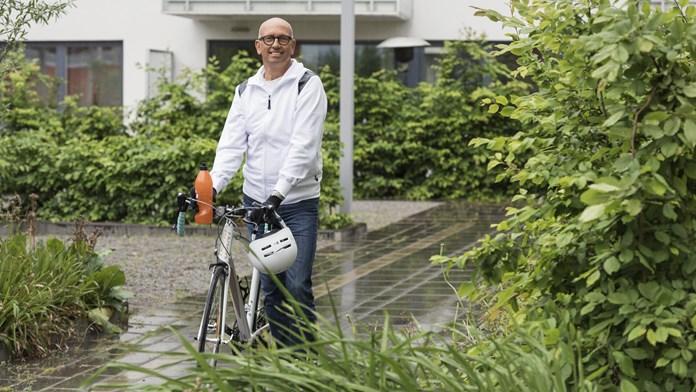 Man med cykel på innergård