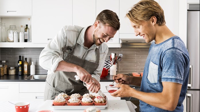 Två ung killar bakar muffins.ar mat